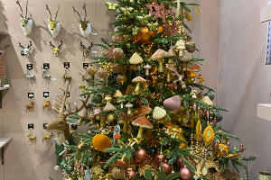 A christmas tree filled with woodland style decorations such as mushrooms and flowers in rustic colours.