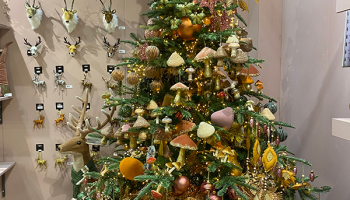 A christmas tree filled with woodland style decorations such as mushrooms and flowers in rustic colours.