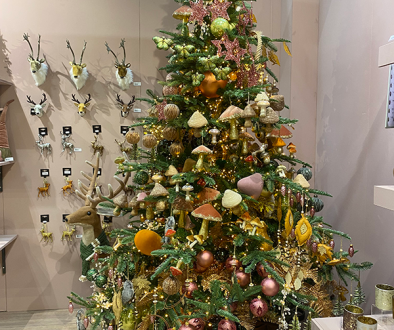 A christmas tree filled with woodland style decorations such as mushrooms and flowers in rustic colours.