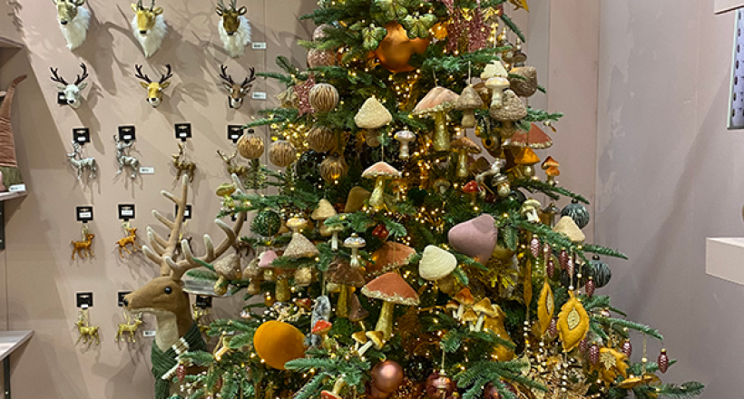 A christmas tree filled with woodland style decorations such as mushrooms and flowers in rustic colours.