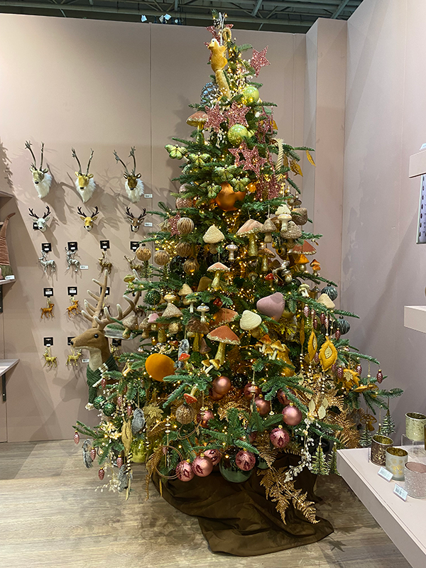 A christmas tree filled with woodland style decorations such as mushrooms and flowers in rustic colours.